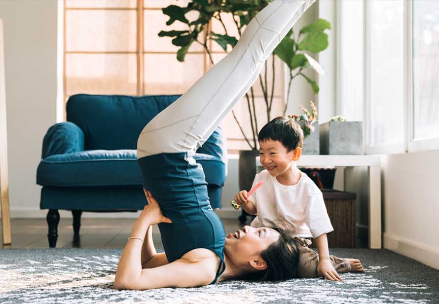 Little boy watching his mother do yoga